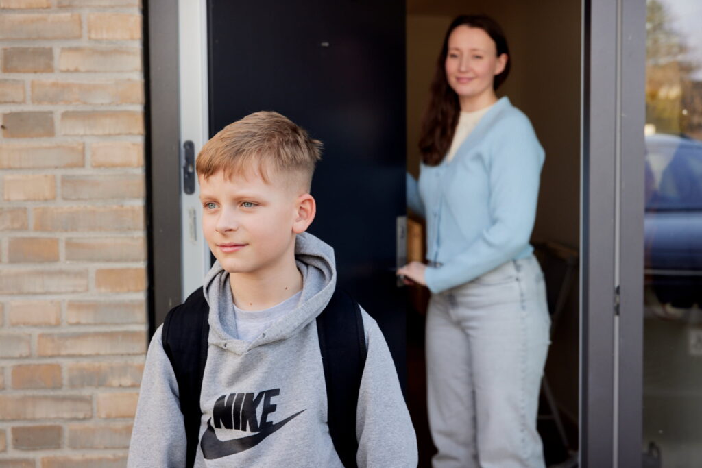 Mor tager afsked med sin dreng, der er på vej ud ad døren